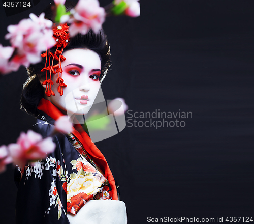 Image of young pretty geisha in kimono with sakura and decoration