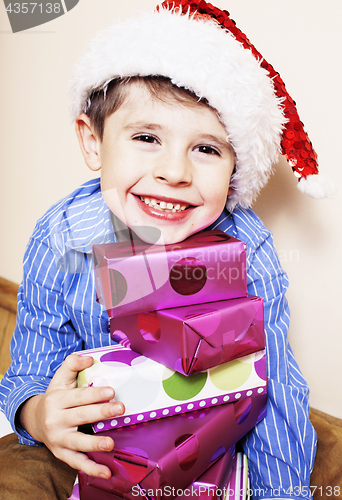 Image of little cute boy with Christmas gifts at home. close up emotional