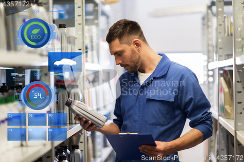 Image of auto mechanic with clipboard at car workshop