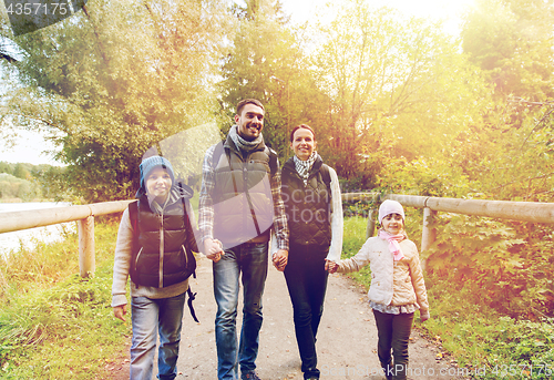 Image of happy family with backpacks hiking in woods