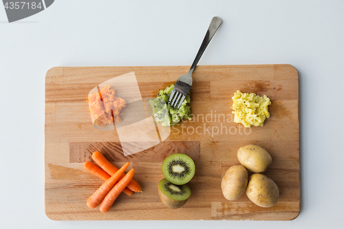 Image of mashed fruits and vegetables with forks on board