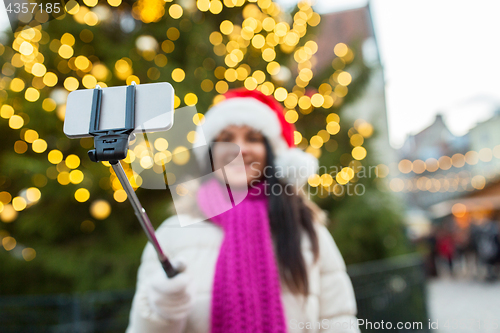 Image of woman taking selfie with smartphone at christmas 