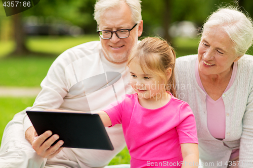 Image of grandparents and granddaughter with tablet pc