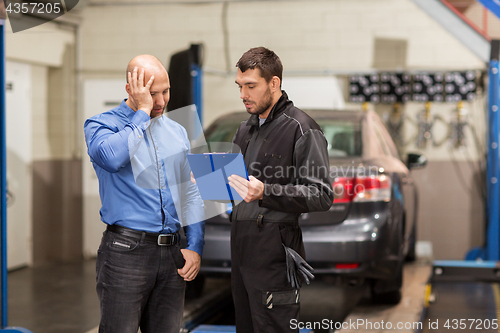 Image of auto mechanic and customer at car shop