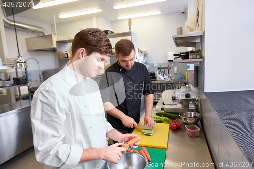 Image of chef and cook cooking food at restaurant kitchen