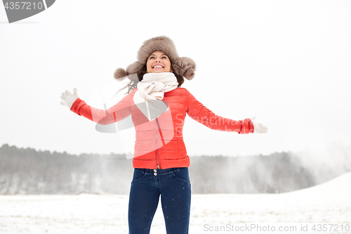 Image of happy woman in winter fur hat having fun outdoors