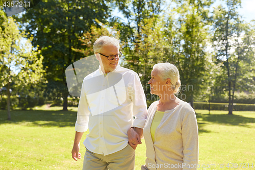 Image of happy senior couple walking at summer city park