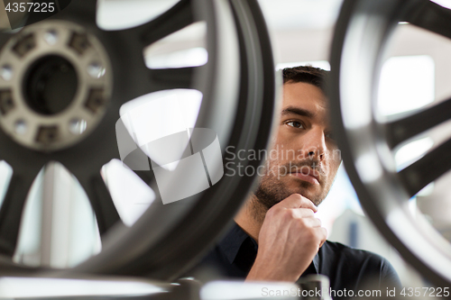 Image of male customer choosing wheel rims at car service