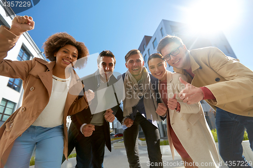 Image of group of people showing thumbs up in city