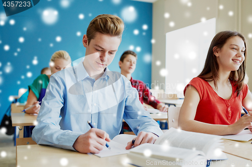 Image of group of students with books writing school test