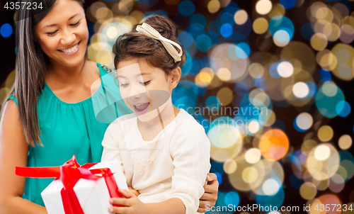 Image of happy mother and daughter girl with gift box