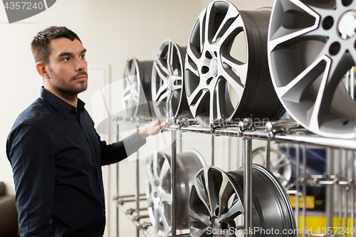 Image of male customer choosing wheel rims at car service