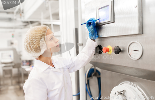 Image of woman programming computer at ice cream factory