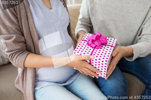 Image of close up of man giving present to pregnant wife