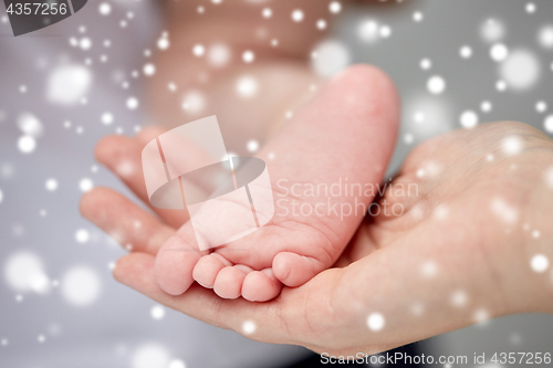 Image of close up of newborn baby feet in mother hands