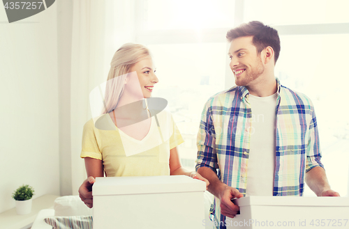 Image of smiling couple with big boxes moving to new home