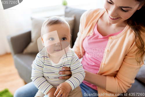 Image of happy young mother with little baby at home