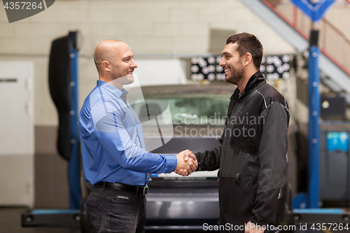 Image of mechanic and customer shaking hands at car service