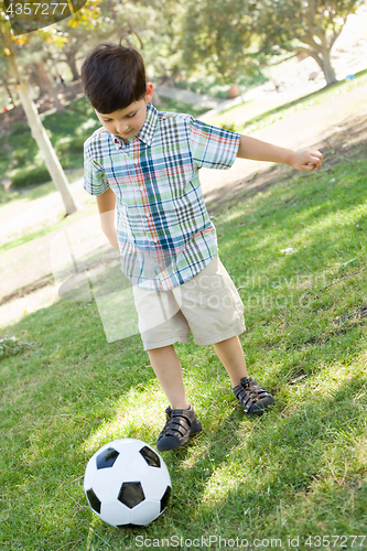 Image of Cute Young Boy Playing with Soccer Ball Outdoors in the Park.