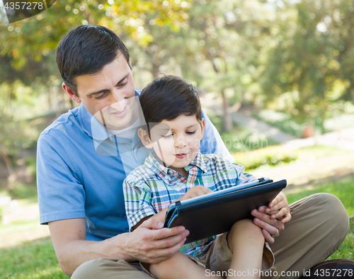 Image of Happy Father and Son Playing on a Computer Tablet Outside.