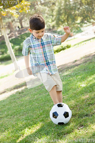 Image of Cute Young Boy Playing with Soccer Ball Outdoors in the Park.