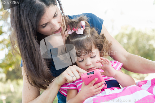 Image of Mixed Race Mother and Cute Baby Daughter Playing with Cell Phone