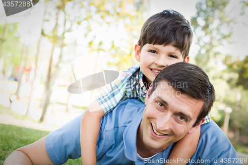 Image of Mixed Race Father and Son Playing Together in the Park.