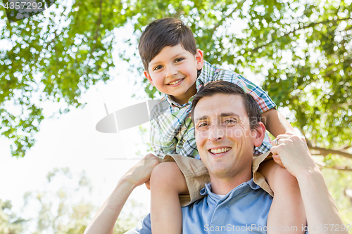 Image of Mixed Race Father and Son Playing Piggyback Together in the Park