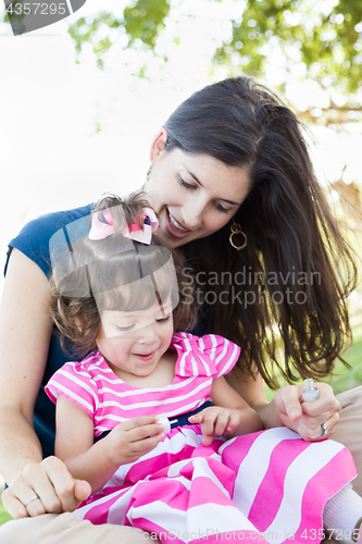 Image of Mixed Race Young Mother and Cute Baby Girl Applying Fingernail P