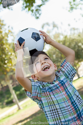 Image of Cute Young Boy Playing with Soccer Ball Outdoors in the Park.