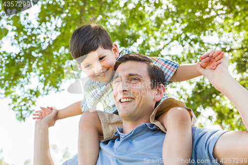 Image of Mixed Race Father and Son Playing Piggyback Together in the Park