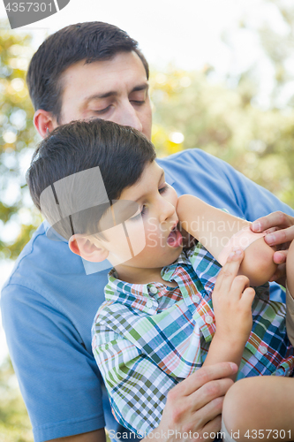 Image of Loving Father Puts a Bandage on the Elbow of His Young Son in th