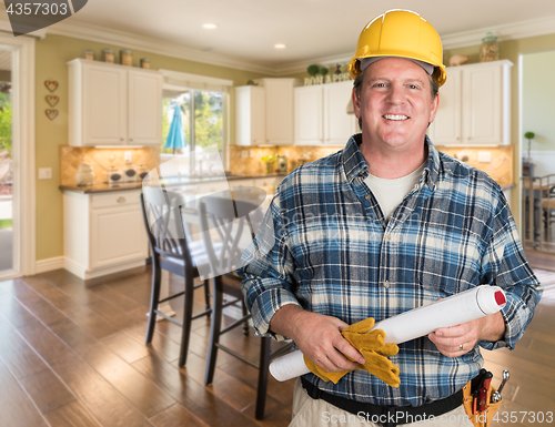 Image of Contractor With Plans and Hard Hat Inside Custom Kitchen.