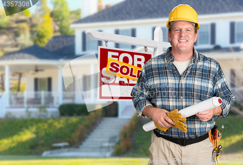 Image of Contractor With Plans and Hard Hat In Front of Sold For Sale Rea