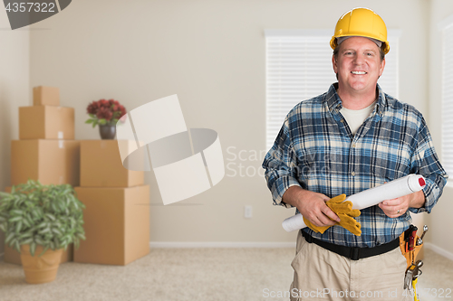 Image of Contractor With Plans and Hard Hat Inside Empty Room with Moving