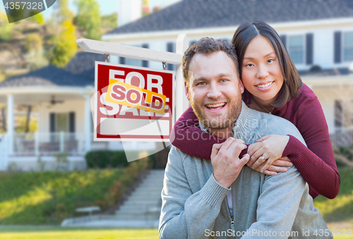 Image of Mixed Race Caucasian and Chinese Couple In Front of Sold For Sal