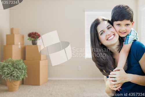 Image of Young Mother and Son Inside Empty Room with Moving Boxes.