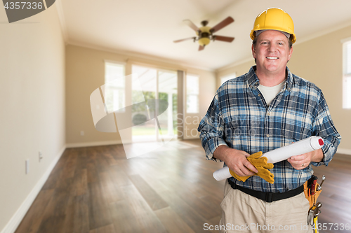 Image of Contractor With Plans and Hard Hat Inside Empty Room with Wood F