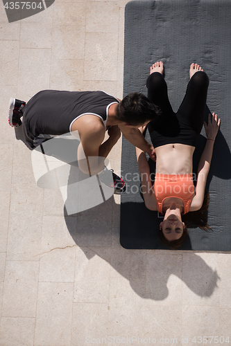 Image of woman with personal trainer doing morning yoga exercises top vie