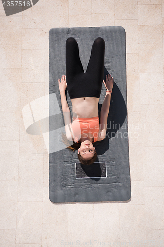 Image of woman doing morning yoga exercises top view