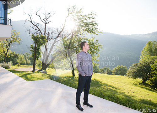 Image of man in front of his luxury home villa