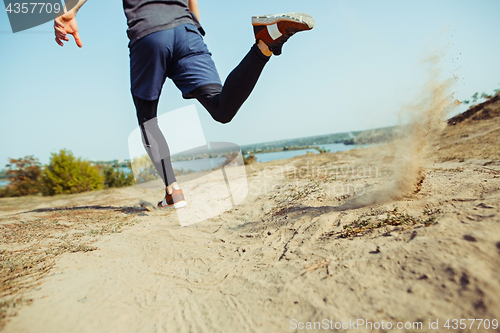 Image of Running sport. Man runner sprinting outdoor in scenic nature. Fit muscular male athlete training trail running for marathon run.