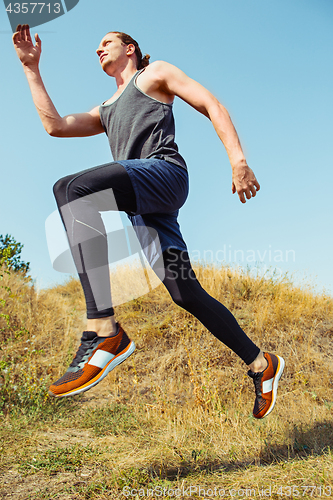 Image of Running sport. Man runner sprinting outdoor in scenic nature. Fit muscular male athlete training trail running for marathon run.