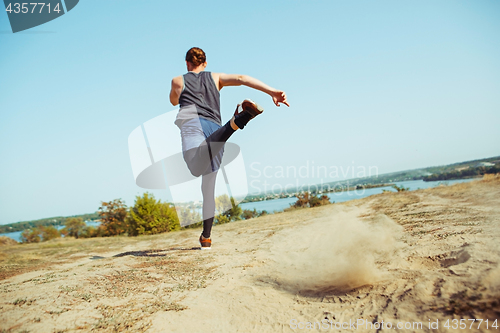 Image of Running sport. Man runner sprinting outdoor in scenic nature. Fit muscular male athlete training trail running for marathon run.