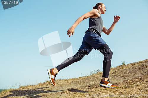 Image of Running sport. Man runner sprinting outdoor in scenic nature. Fit muscular male athlete training trail running for marathon run.