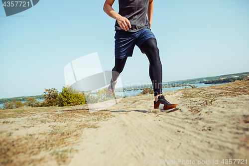 Image of Running sport. Man runner sprinting outdoor in scenic nature. Fit muscular male athlete training trail running for marathon run.