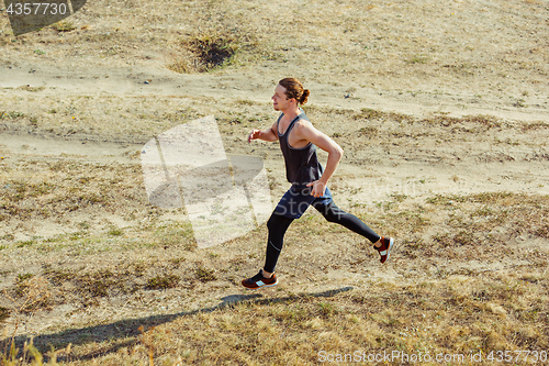 Image of Running sport. Man runner sprinting outdoor in scenic nature. Fit muscular male athlete training trail running for marathon run.