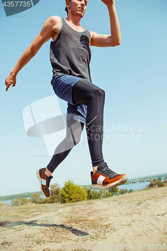 Image of Running sport. Man runner sprinting outdoor in scenic nature. Fit muscular male athlete training trail running for marathon run.