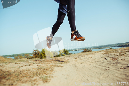 Image of Running sport. Man runner sprinting outdoor in scenic nature. Fit muscular male athlete training trail running for marathon run.