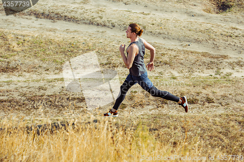 Image of Running sport. Man runner sprinting outdoor in scenic nature. Fit muscular male athlete training trail running for marathon run.